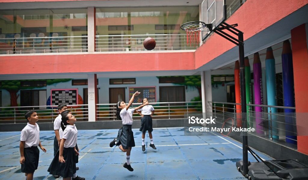 Students playing basketball during school break, showing the strong connection between basketball and students.